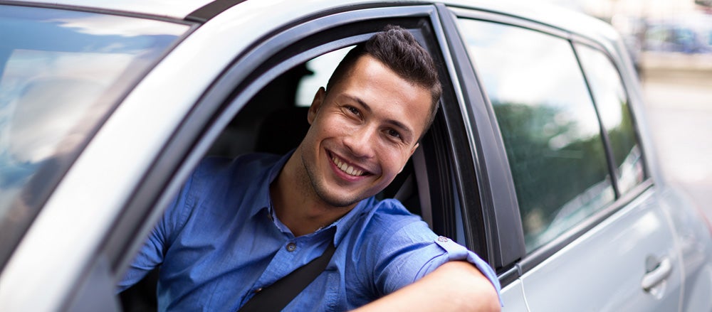 Man Smiling While Driving Vehicle